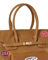 Vale Forever Lucky Charms Bag tan, close-up of the twin leather top handles, gold turn-lock and Valley Dreams 14-97 patch