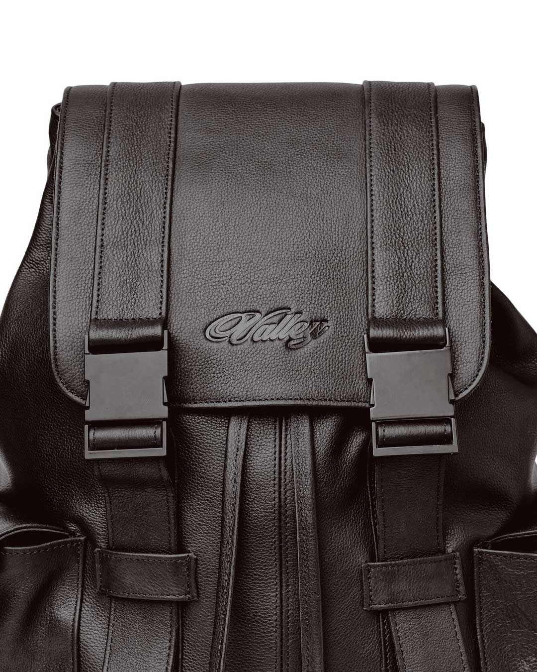 Vale Forever Tactician Backpack chocolate, close-up of the embossed Valley script and buckle hardware on the flap
