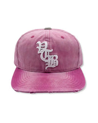 Vertabrae Pink Snapback, washed pink twill cap with white old-English embroidered monogram and distressed brim, front view