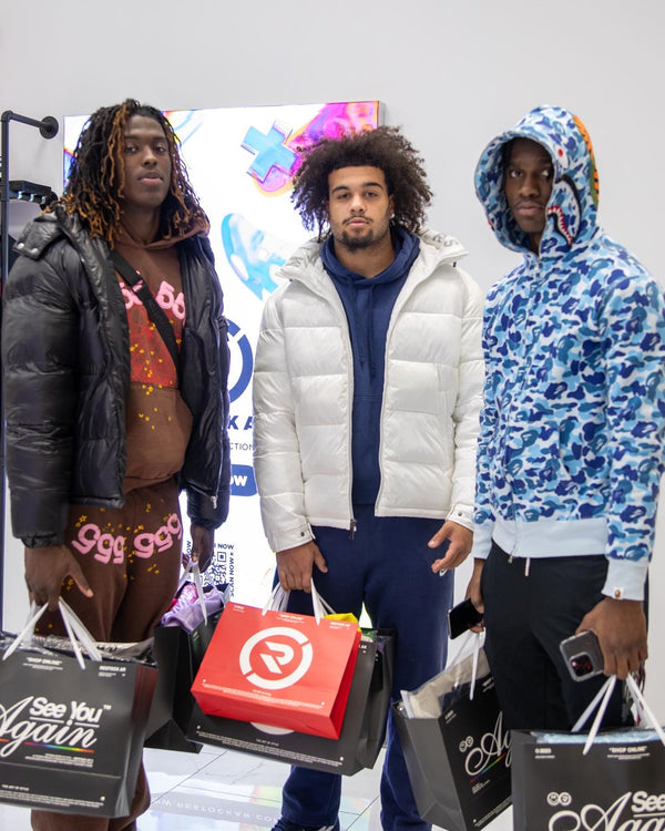 Customers with Restock AR shopping bags in store